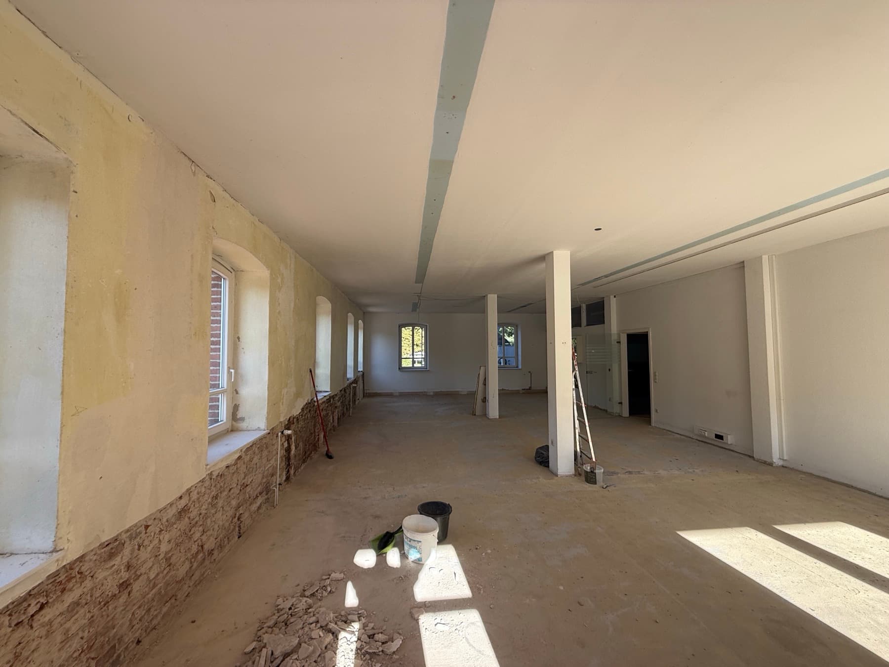Offene, entkernte Fläche mit Stahlstützen und Fensterreihe – bereit für den Ausbau